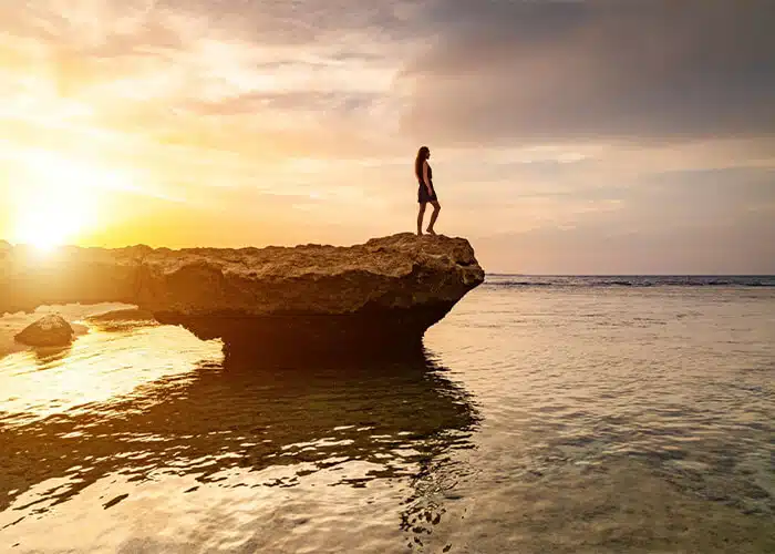 A-girl-stands-on-a-rock-on-a-beach-in-Egypt Beach in Egypt